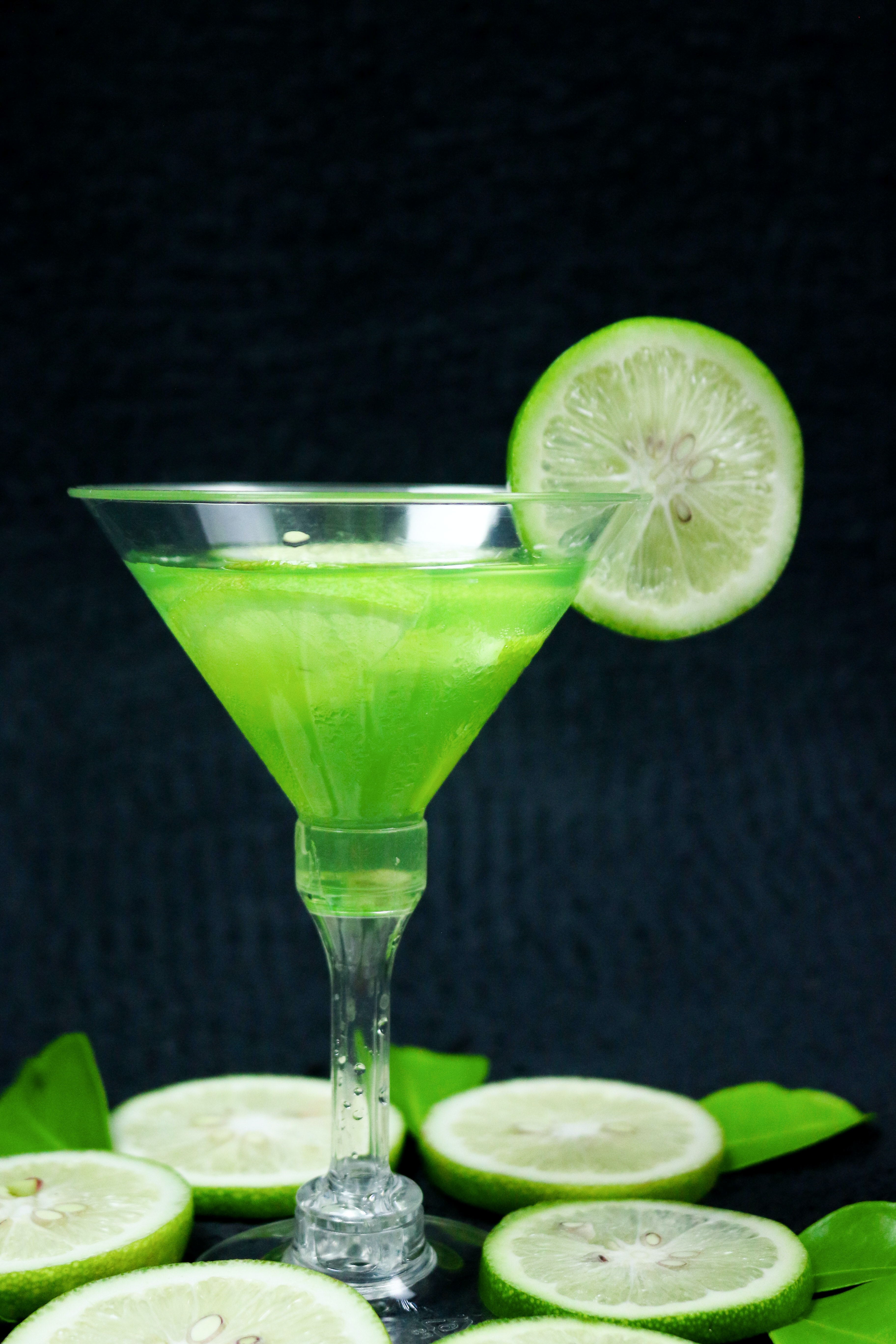 Picture of a Japanese Slipper cocktail. Green cocktail, garnished with a lime wheel.